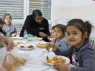 Mädchen essen im CONCORDIA Tageszentrum im Kosovo